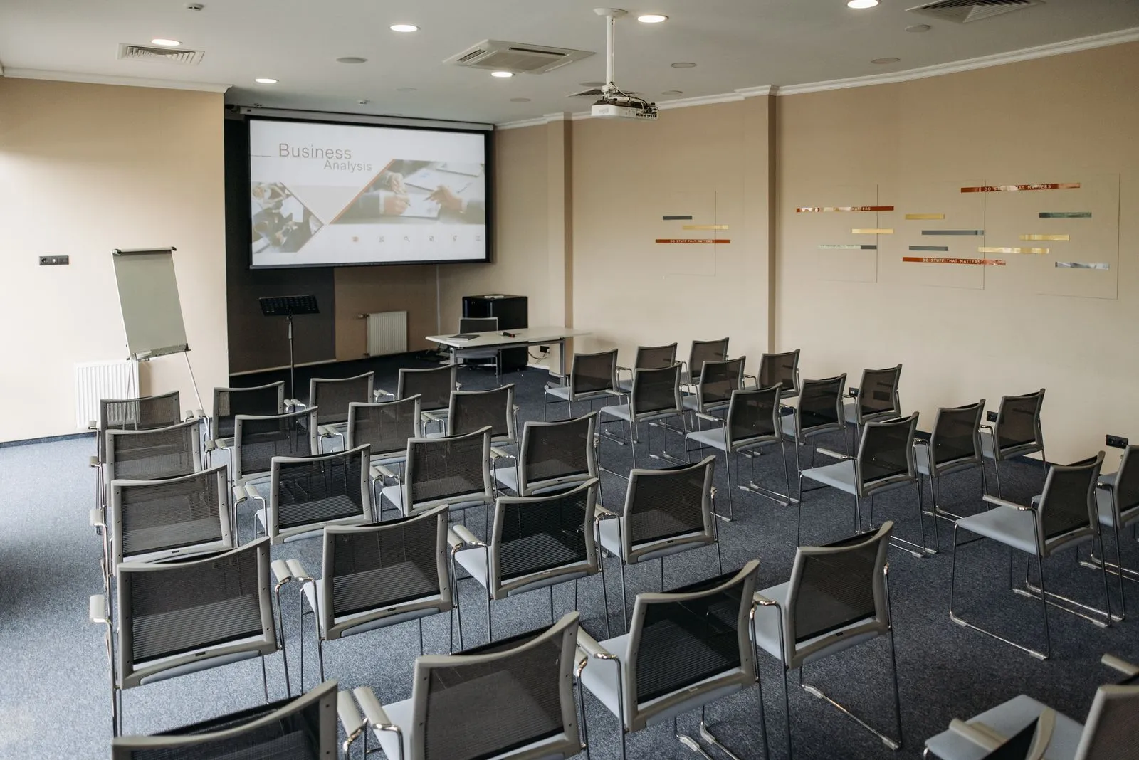 Participants attablés dans une salle de séminaire lumineuse, notes et ordinateurs ouverts devant eux